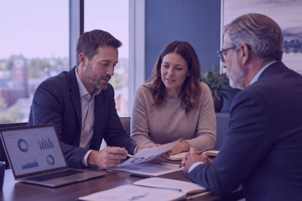 Financial professionals discussing program data and reporting during a business review.
