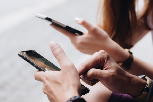 Two people using smartphones, illustrating the importance of digital banking access and timely account information.